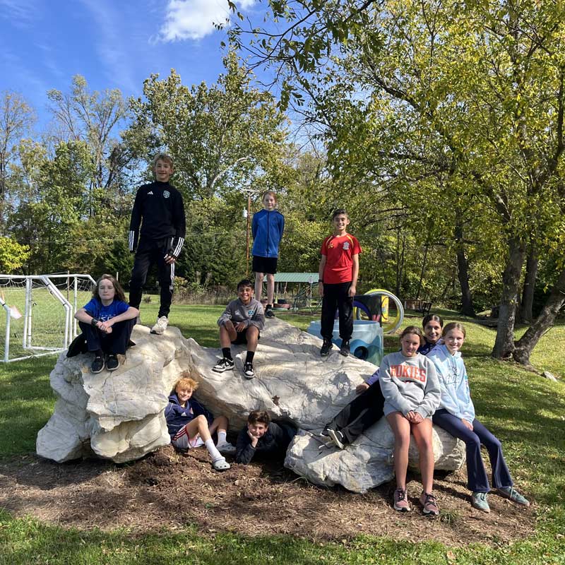 A diverse group of students gather near the activity fields at Community School, a private school near Roanoke, Virginia.